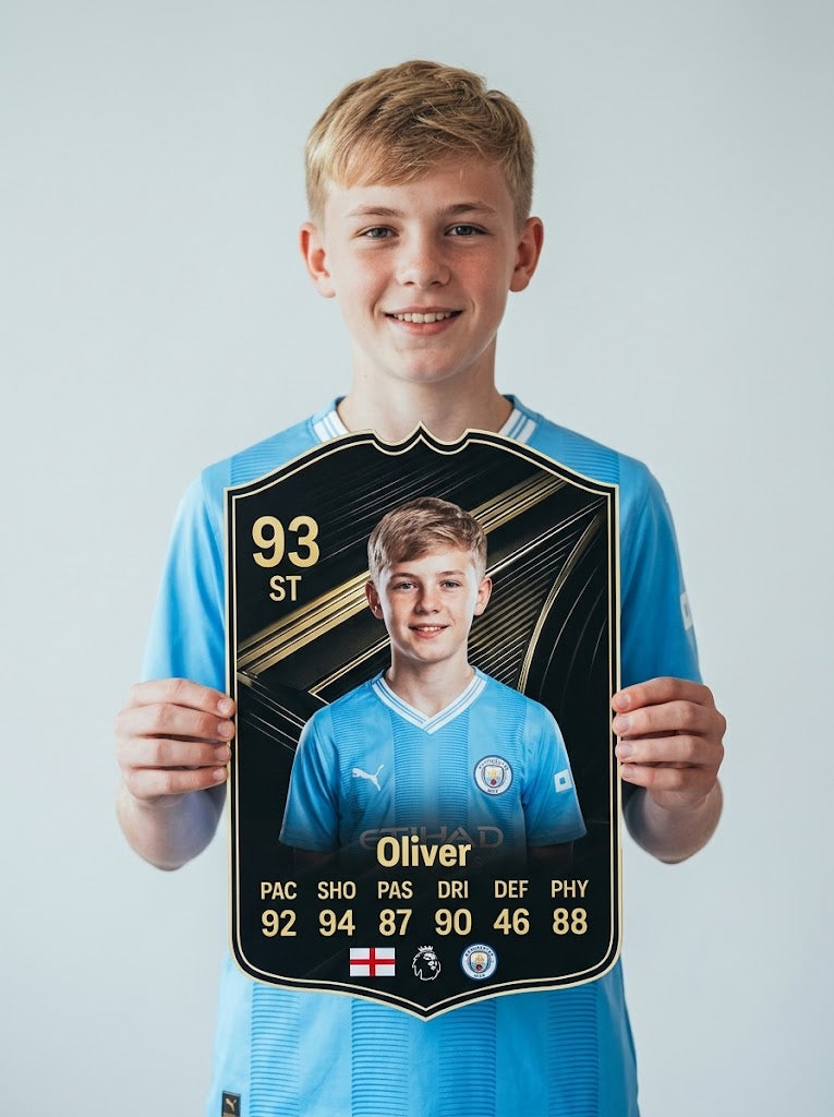 Chico con camiseta del Manchester City sosteniendo su carta de FIFA FC 26 Team of The Week personalizada, un regalo de CardsGoat