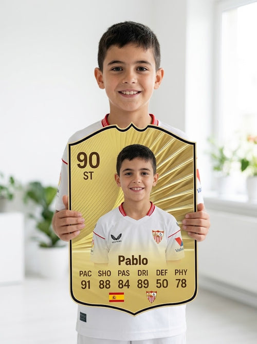 Niño con camiseta del Sevilla FC sosteniendo su carta de FIFA FC 26 Gold personalizada — CardsGOAT