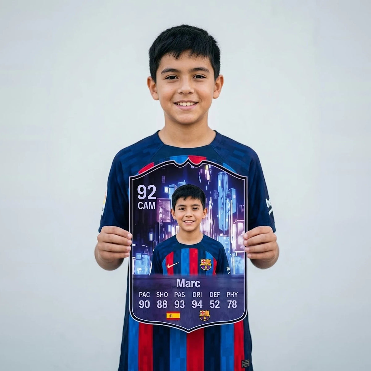 Niño con camiseta del FC Barcelona sosteniendo su carta de FIFA FC 26 Flashback personalizada — CardsGoat